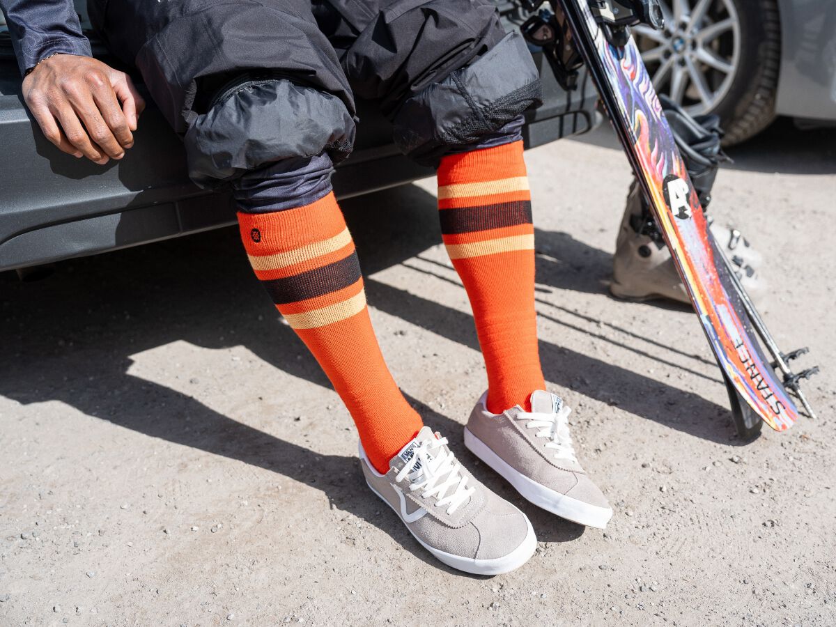 Person wearing orange snow socks and vans